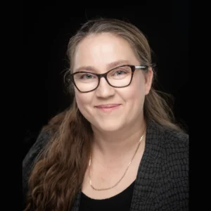Jessie Rock headshot, she has on a black blazer and wearing glasses